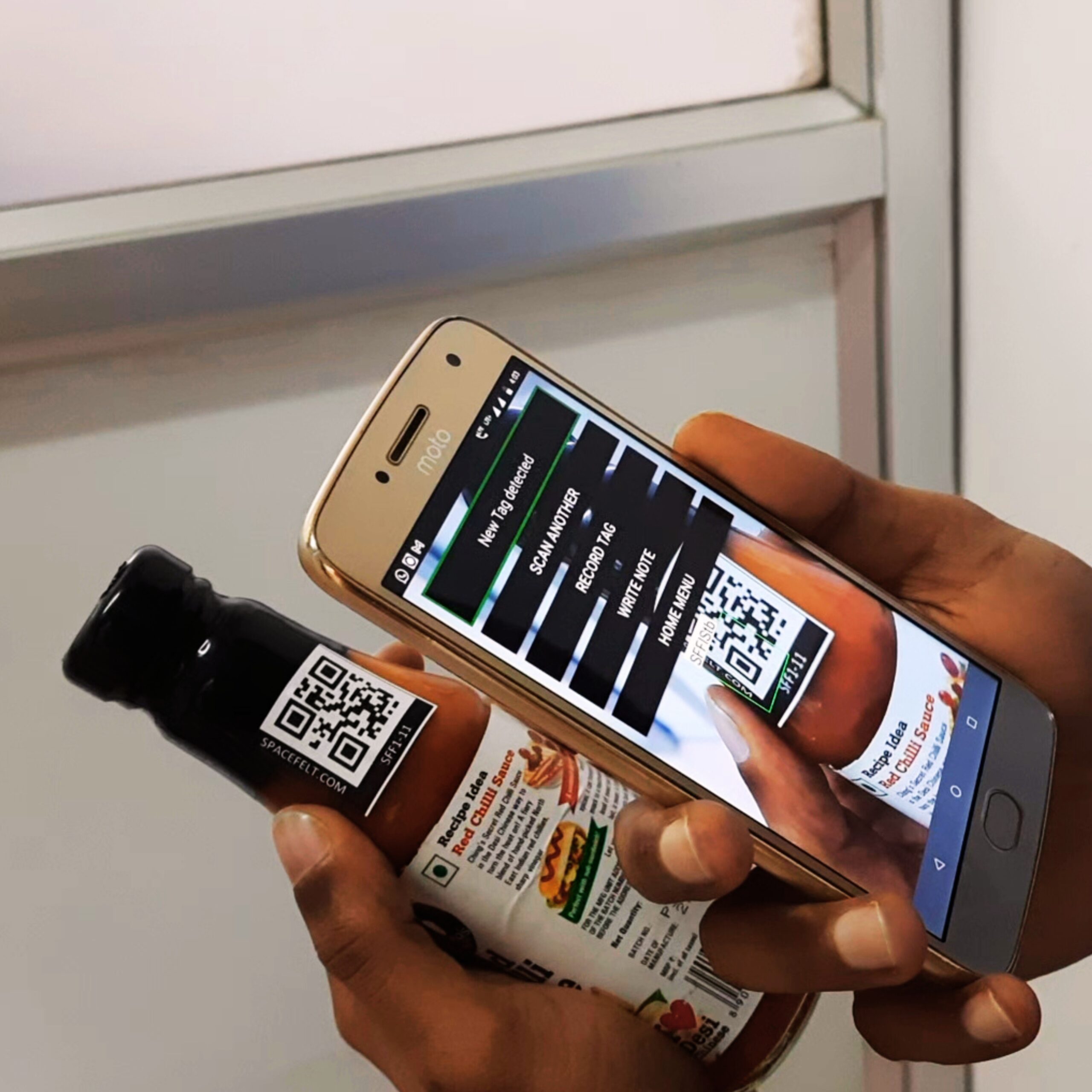 Person scanning a QR code label on a bottle using the Spacefelt app to access audio information.